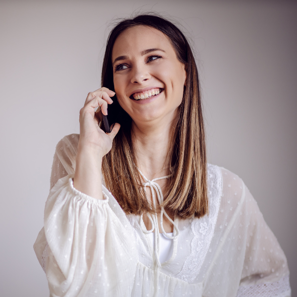Woman smiling while talking on the phone after her appointment at Phase II Center for Women's Health